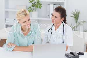 Patient and doctor looking at computer