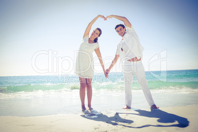 Happy couple forming heart shape with their hands