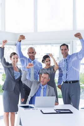 Smiling business team celebrating and looking at camera