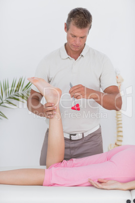Physiotherapist using reflex hammer