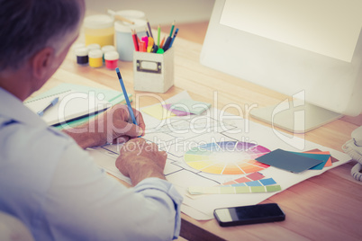 Creative businessman drawing plans using colour watch