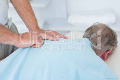 Physiotherapist doing shoulder massage to his patient