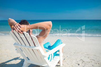 Man relaxing on deck chair at the beach