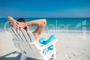 Man relaxing on deck chair at the beach