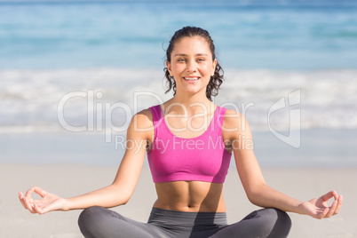 Fit woman doing yoga beside the sea