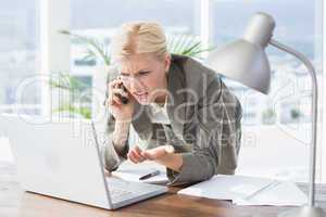 Businesswoman on the phone and using her laptop