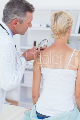Doctor examining his patient with magnifying glass