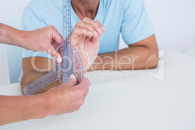Doctor measuring wrist with goniometer