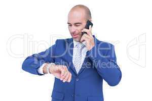 businessman talking on the phone and looking at his watch