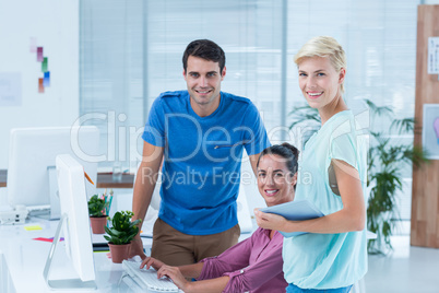 Three casual colleagues using computer