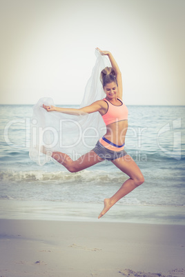 Fit woman jumping on the beach