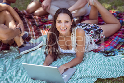 Pretty brunette using laptop in the park