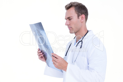 Serious young doctor looking at x-ray