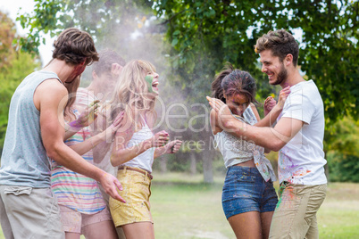 Happy friends throwing powder paint