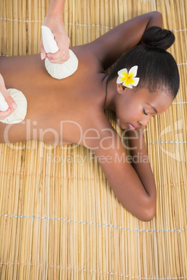 Pretty woman enjoying a herbal compress massage