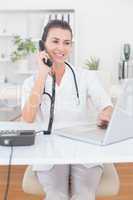 Doctor doing phone call while she using computer