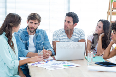 Colleagues using laptop at office