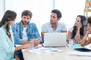 Colleagues using laptop at office