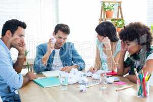 Exhausted business team making paper pellet