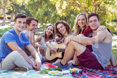 Happy friends in the park having picnic