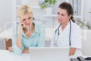 Patient and doctor looking at computer