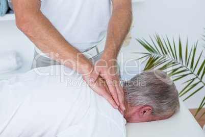 Physiotherapist doing neck massage to his patient