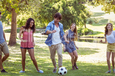 Happy friends in the park with football