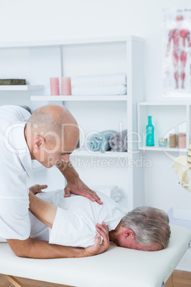 Physiotherapist doing shoulder massage to his patient