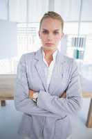 Unhappy businesswoman looking at camera with arms crossed