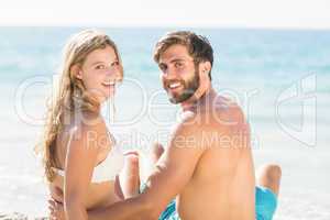 Happy couple relaxing together in the sand