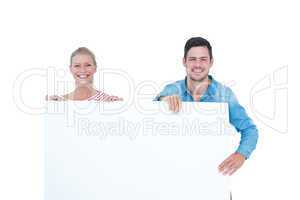 Smiling young couple holding a blank sign