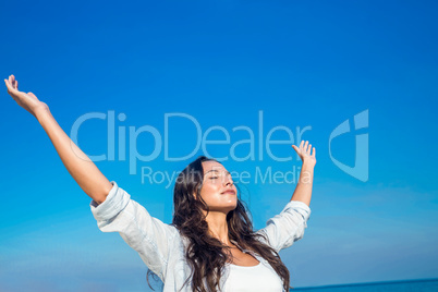 Happy woman with eyes closed at the beach