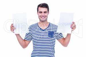 Handsome hipster holding sheets of paper