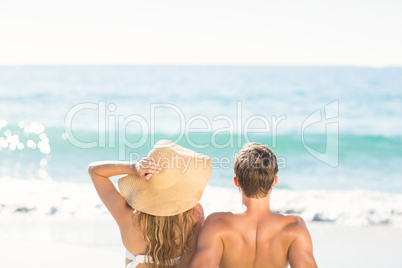 Happy couple relaxing together in the sand