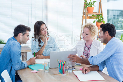 Group of young colleagues using laptop in a meeting