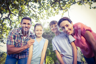 Happy family smiling at camera in the park