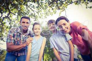 Happy family smiling at camera in the park