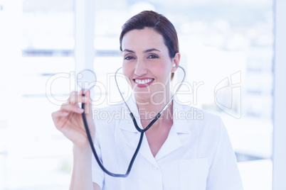 Smiling doctor looking at camera and showing stethoscope