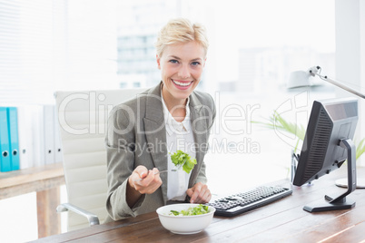 Businesswoman eating salad on her desk