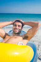 Handsome man lying on the beach looking at camera