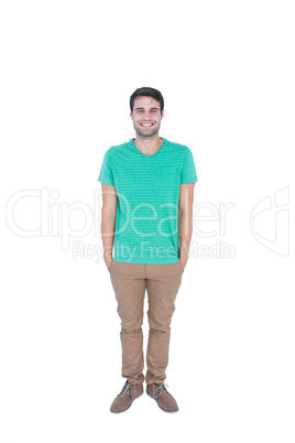 Happy handsome man looking at camera with hands in pocket