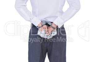 Wear view of businessman with handcuff and money in hands