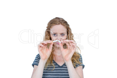 Serious blonde woman snapping cigarette