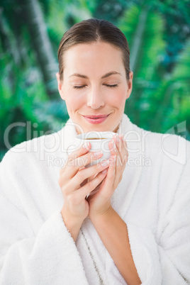 Close up portrait of a beautiful young woman drinking a tea