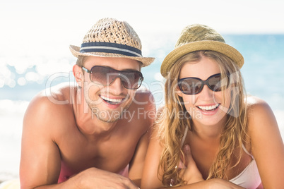 Happy couple relaxing together in the sand