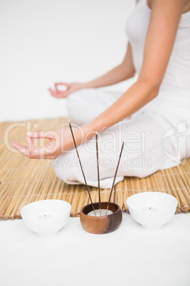 Fit woman meditating on bamboo mat