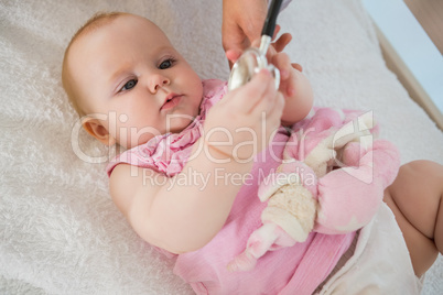 Beautiful cute baby girl with doctor with stethoscope