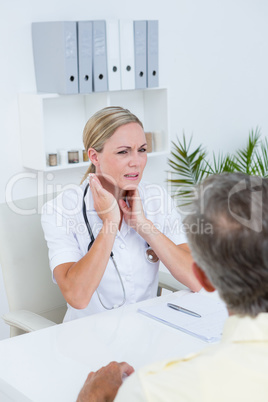 Doctor examining patient with neck ache