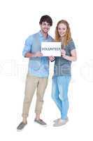 Happy couple holding a volunteer note