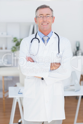 Smiling doctor looking at camera with arms crossed